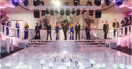 The Function Band perform on stage at a grand white dance floor