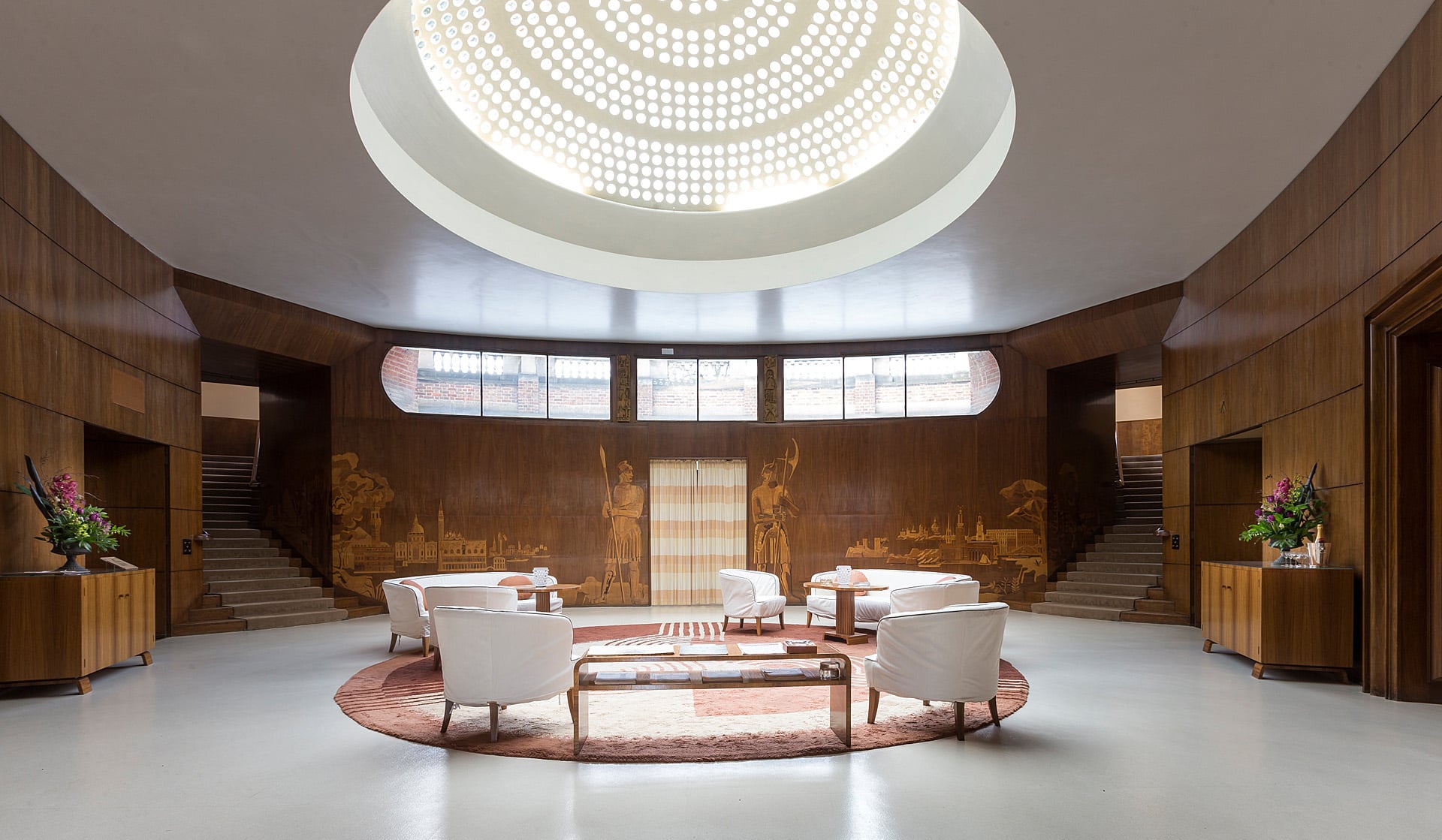 The Art Deco Entrance Hall, its glass dome, marquetry murals and twin staircases