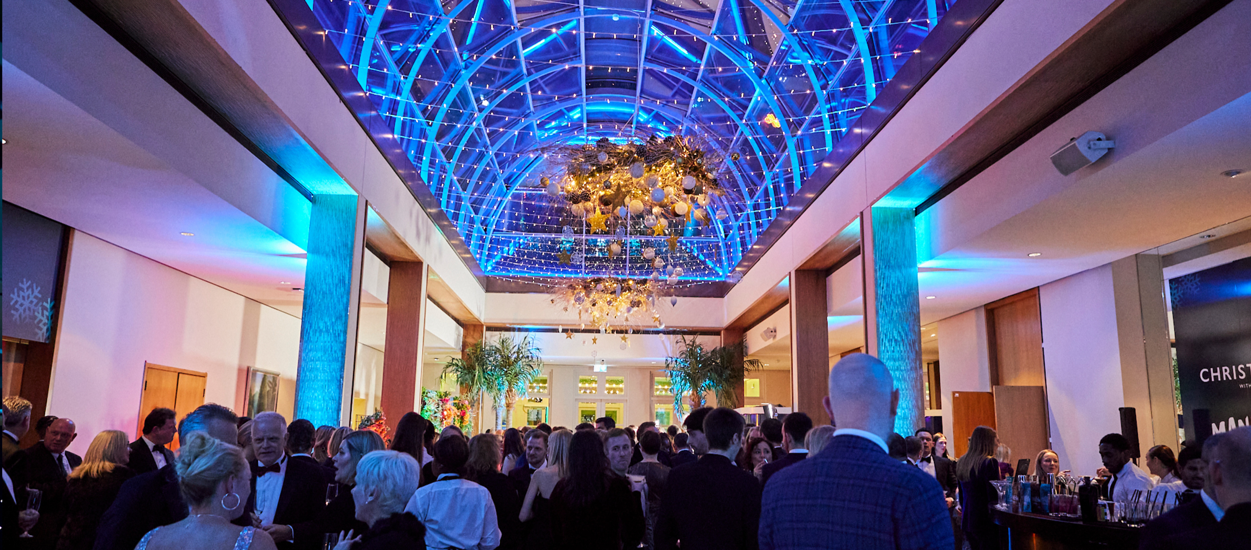 A drinks reception under the illuminated Palm Court dome