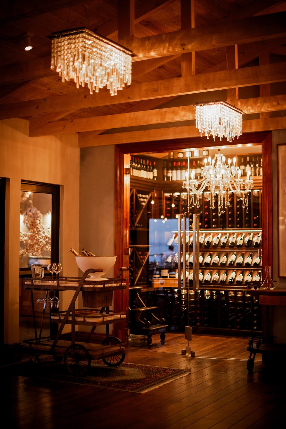 The dining room, chandeliers and a lit wine display