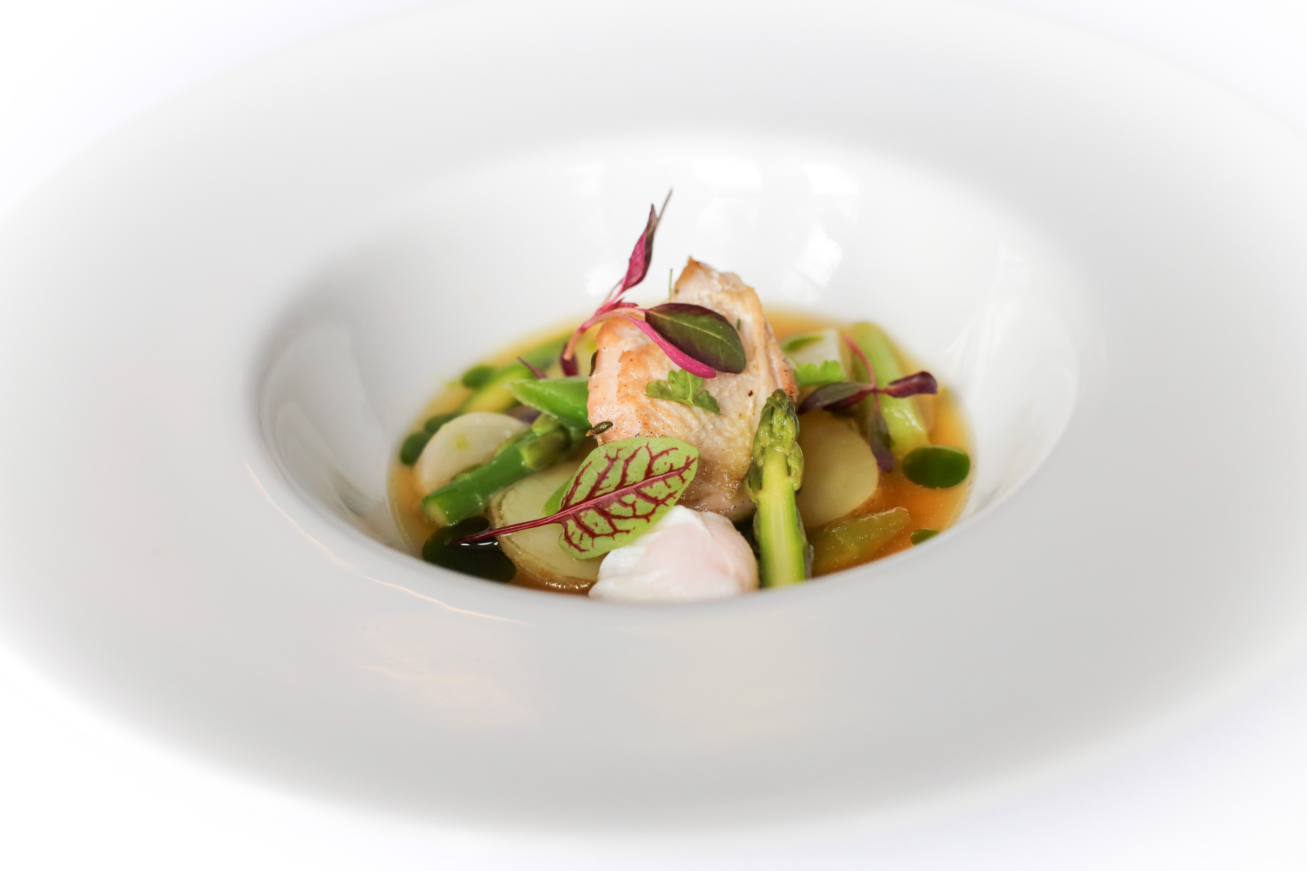 Quail with a clear consomme and summer vegetables