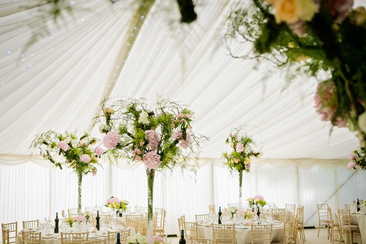 Charlotte and Joe's marquee reception, tall floral centrepieces