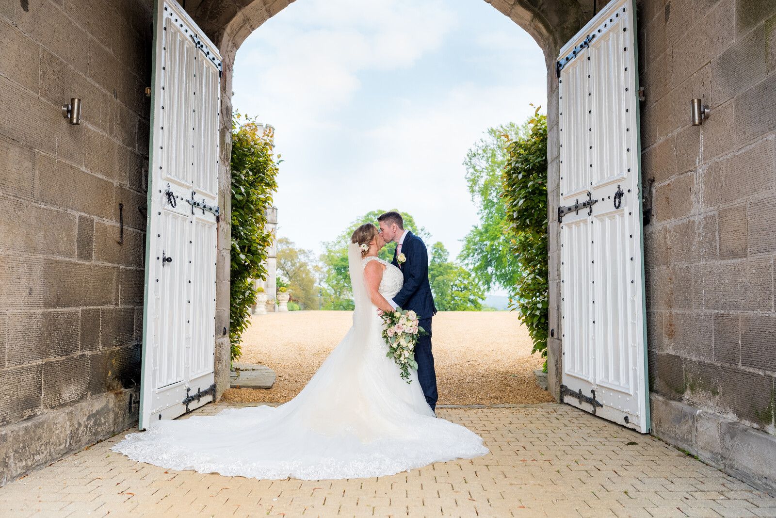 A bride and groom embracing in the arched castle doorway