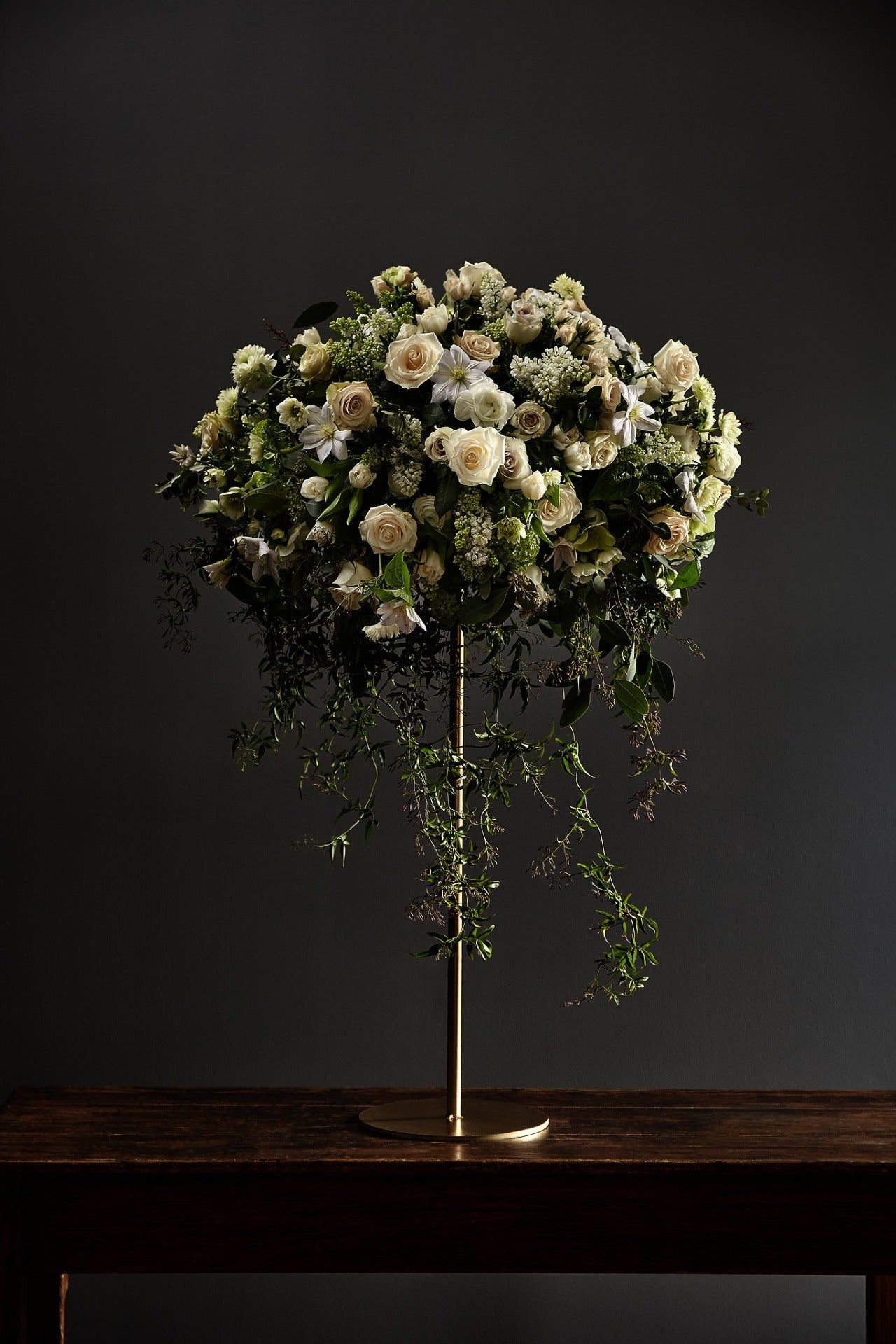 A loose, seasonal arrangement of poppy and ranunculus in a glass compote