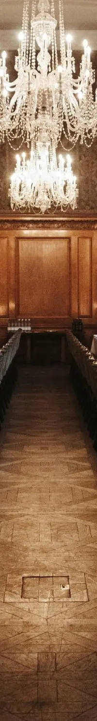 The walnut-panelled Tapestry Room at The Ned, set by candlelight for a wedding