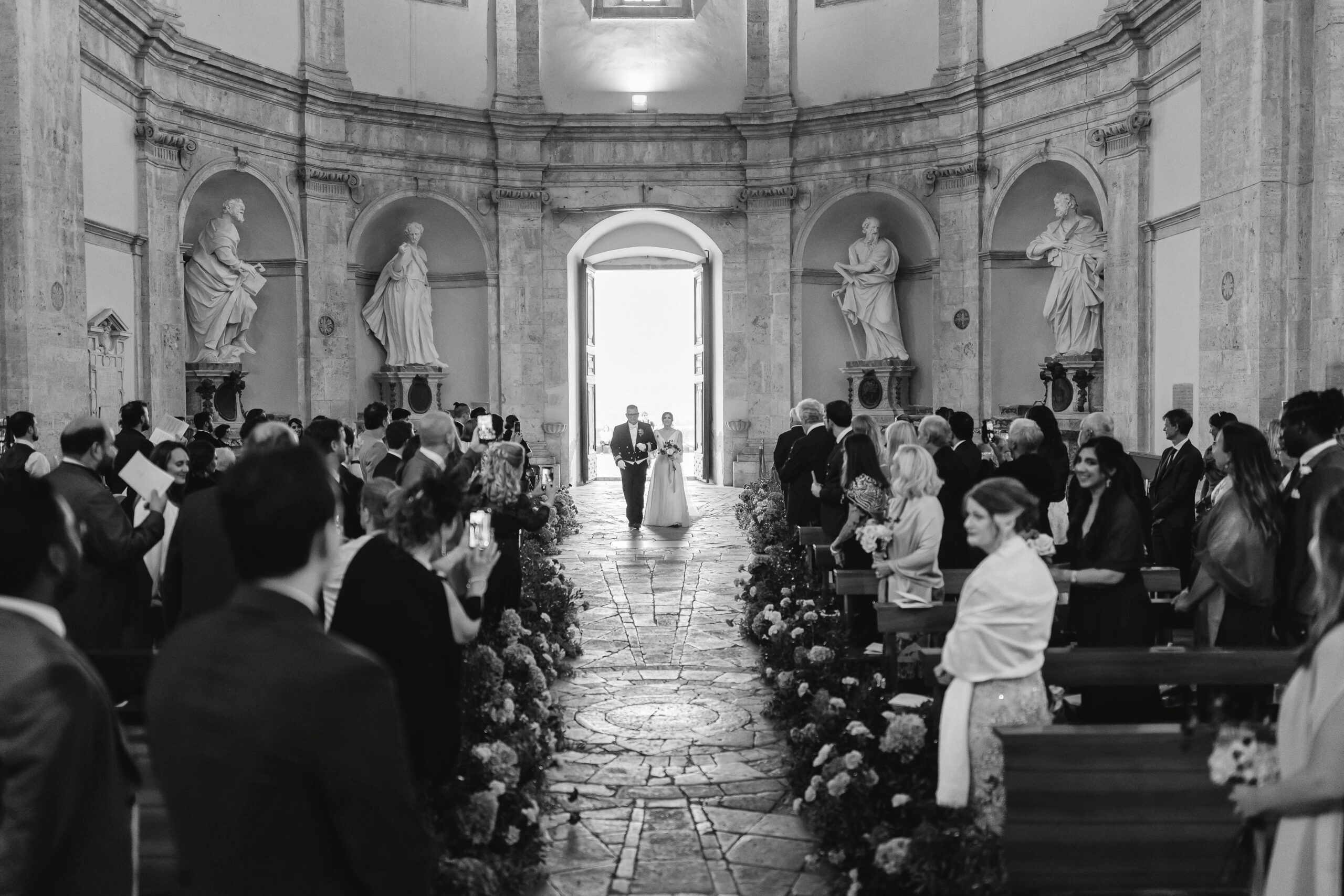 A domed church, statues in the niches, the aisle lined with flowers