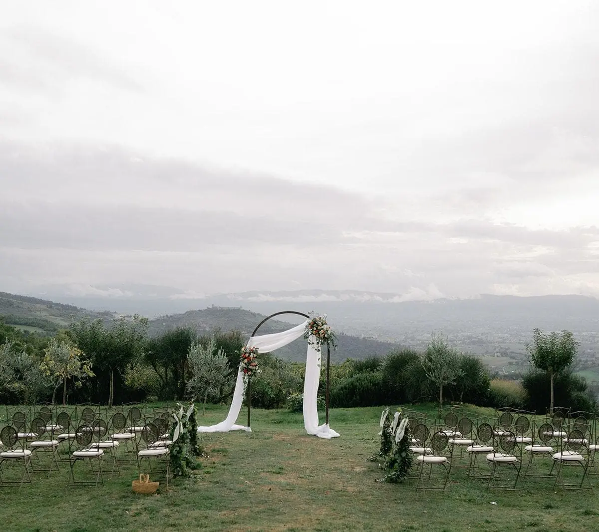 A wedding ceremony arch on a ridge above an Umbrian valley