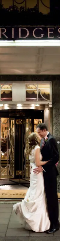 A newly married couple kissing outside Claridge's, London