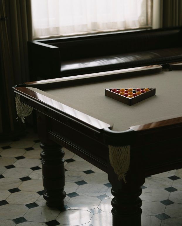 The panelled billiards room with a full-size pool table on a chequerboard floor