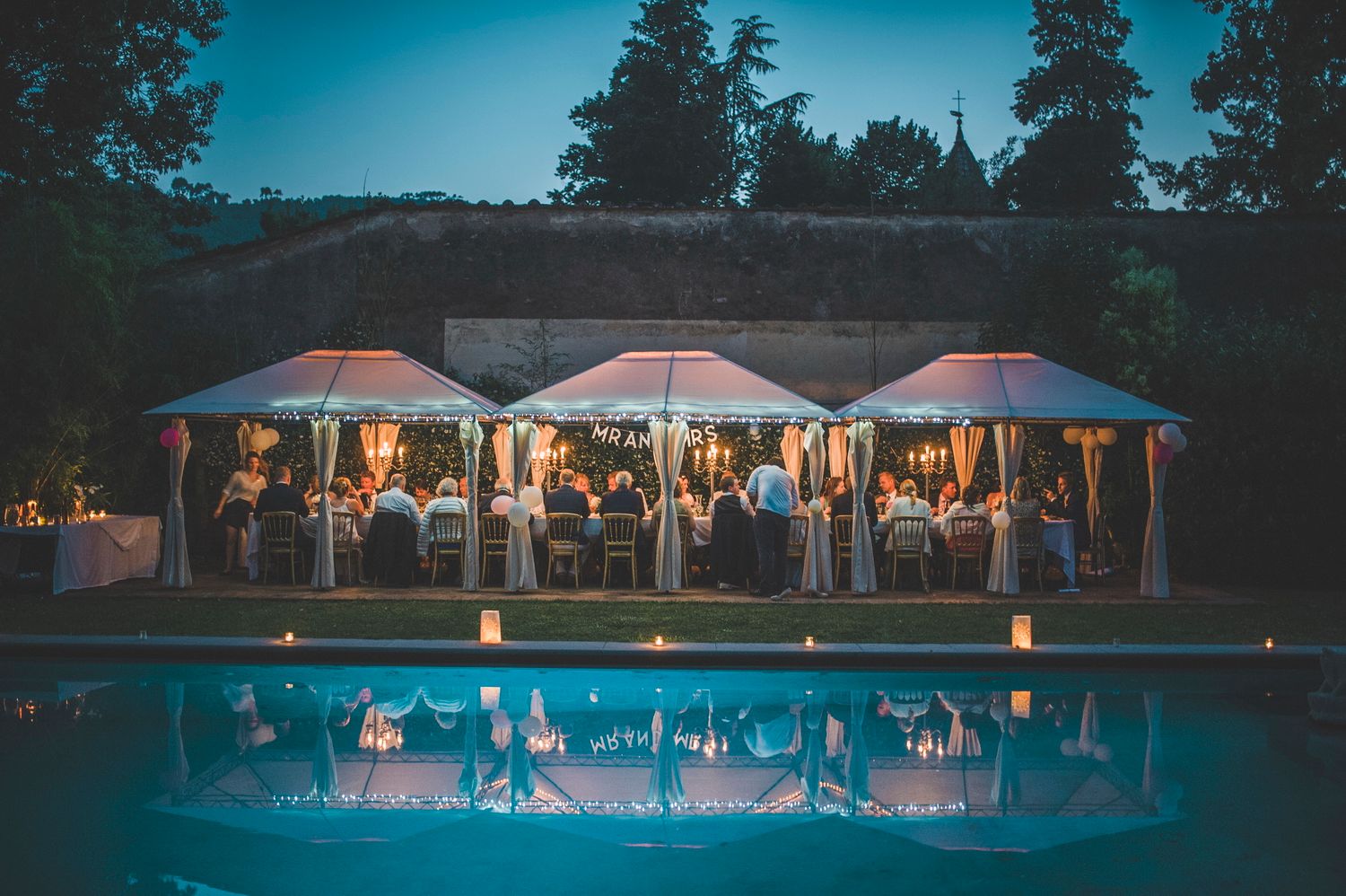An evening reception by the pool at dusk, Villa Michaela, Lucca, Italy