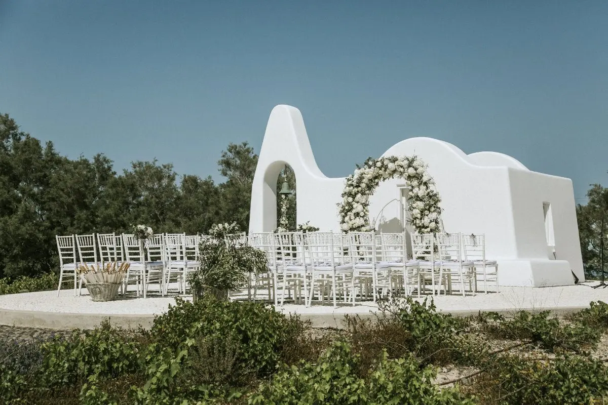 A whitewashed ceremony arch above the caldera