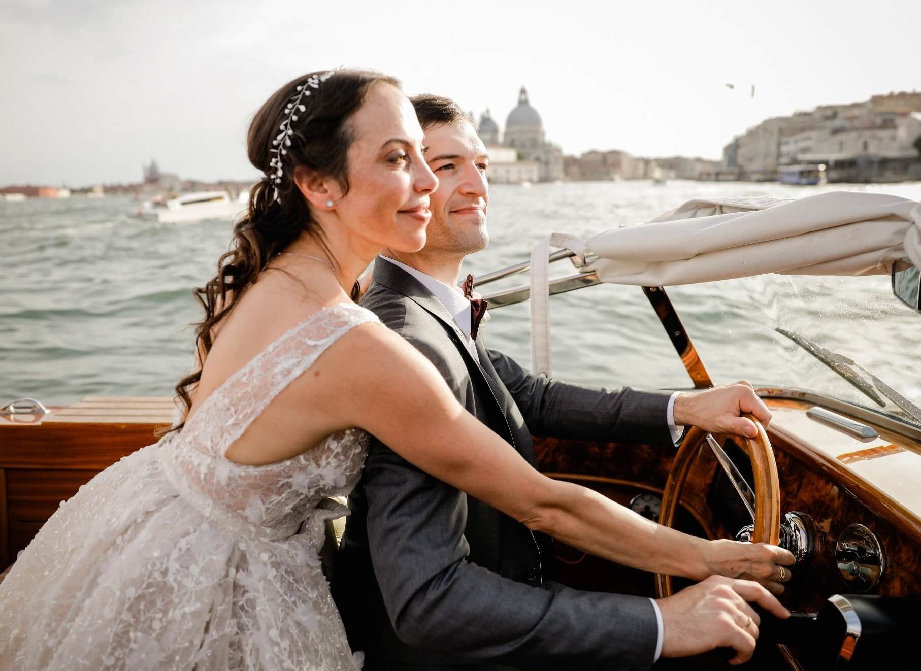 Aboard a wooden launch, the coast behind them