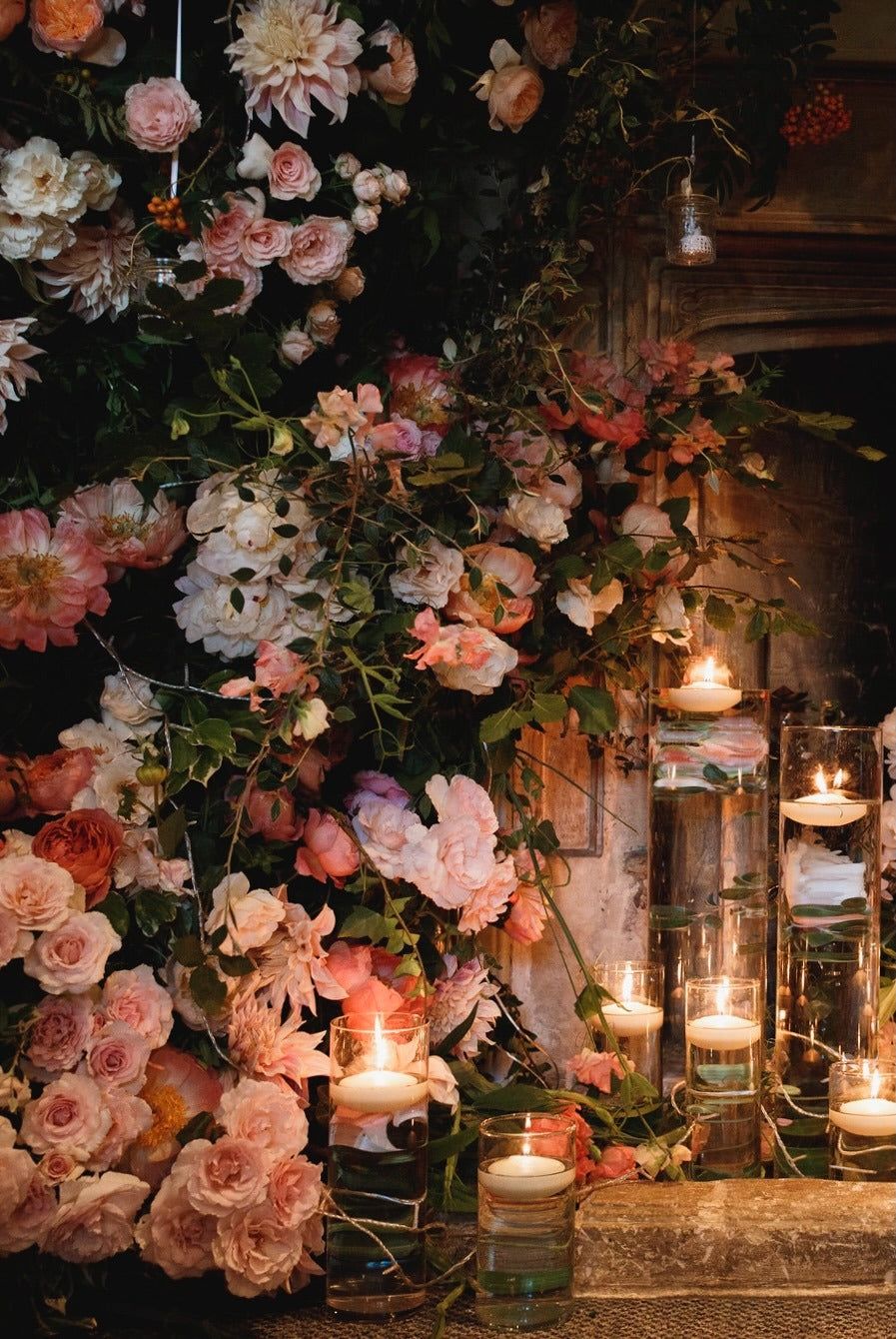 Candlelight along the fireplace floral installation, Barnsley House, McQueens Flowers, London, England