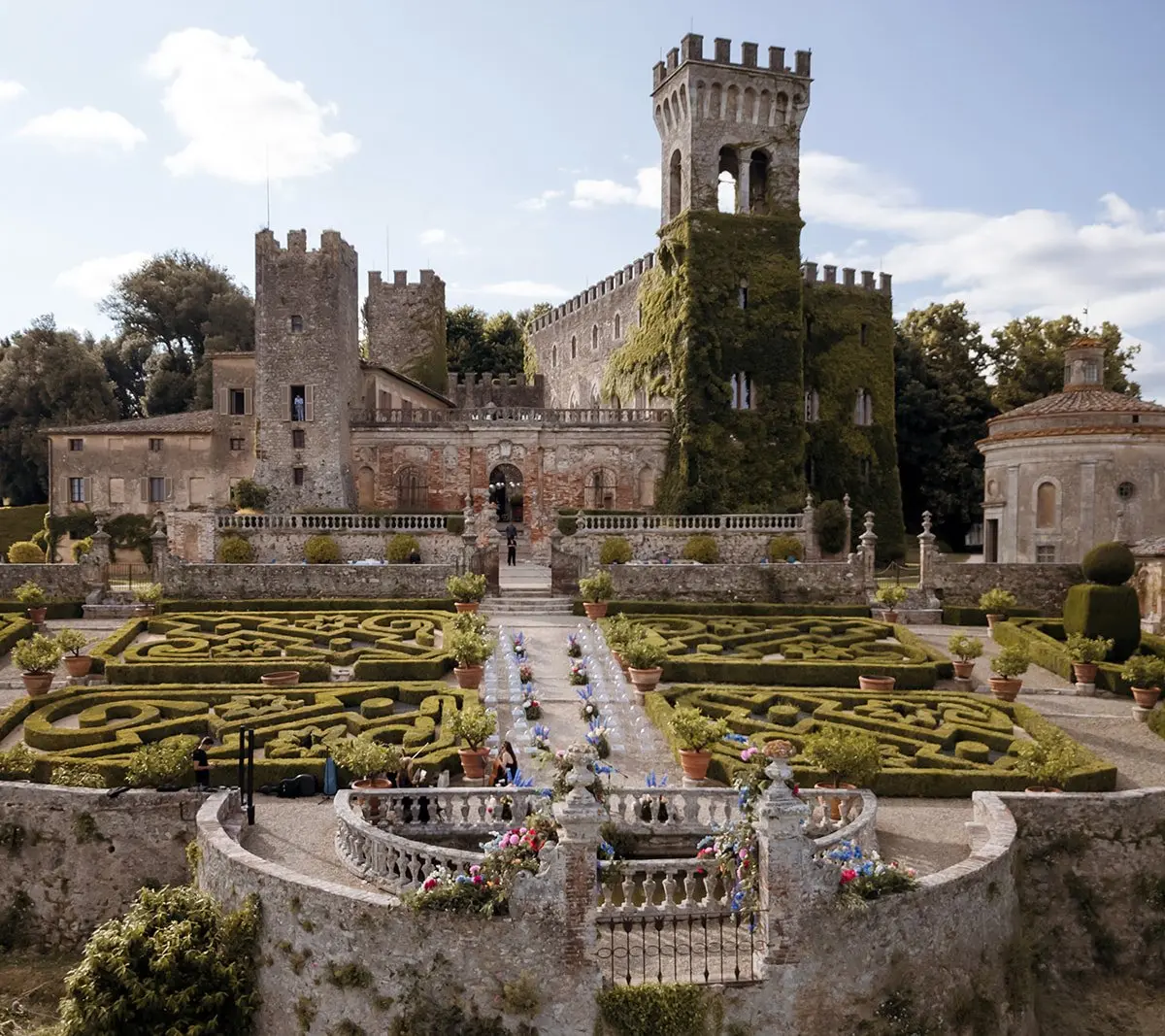 Castello di Celsa's stone towers above a geometric parterre garden, Siena