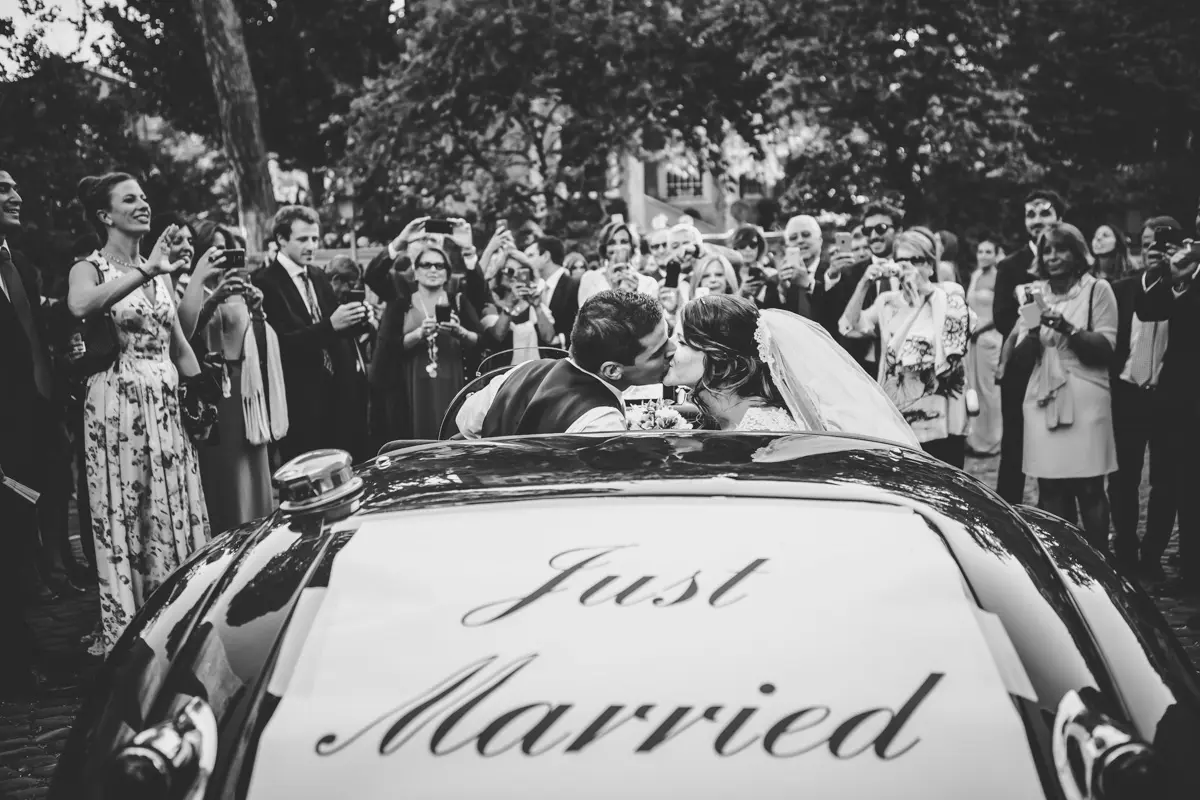 A kiss in the crowd, the Just Married sign on the car, Silvia Cleri Photography, Rome, Italy