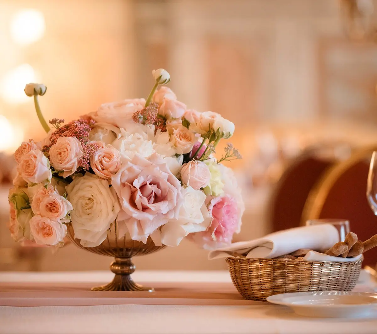 A rose centrepiece in a gold urn on a set table at Grand Hotel Continental, Siena