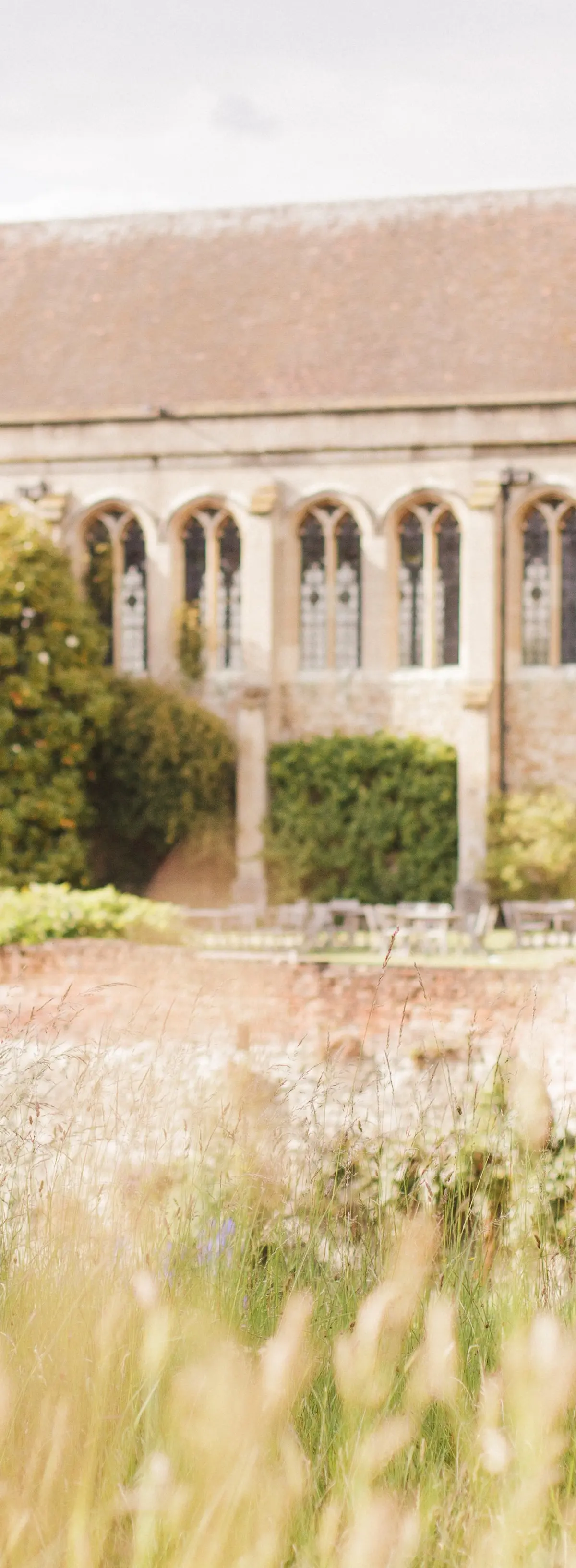 A couple in the meadow, the medieval Great Hall rising behind