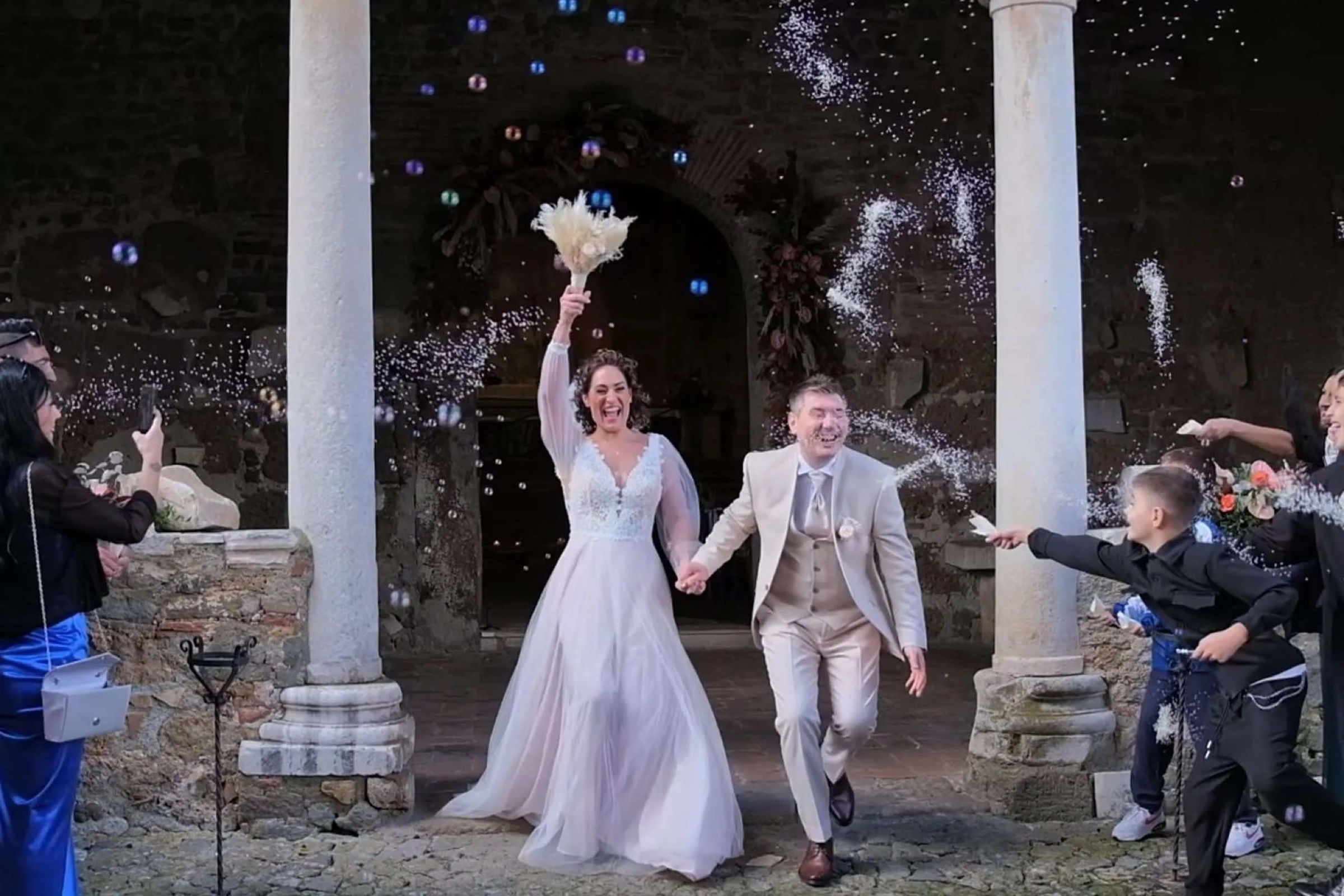 A couple with sparklers, in a Roman colonnade