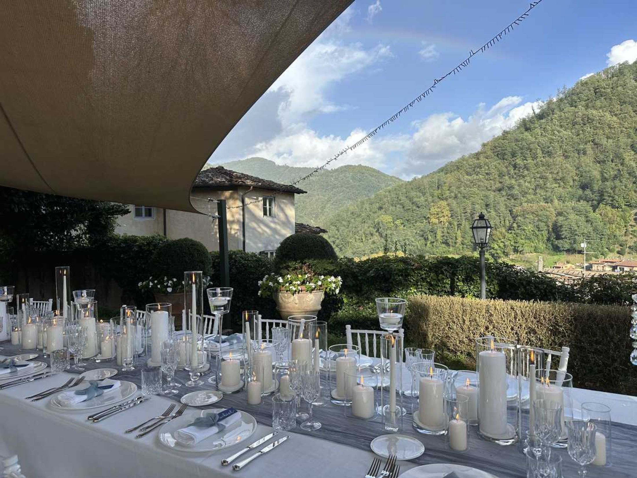 A long table under the canopies, the hills beyond