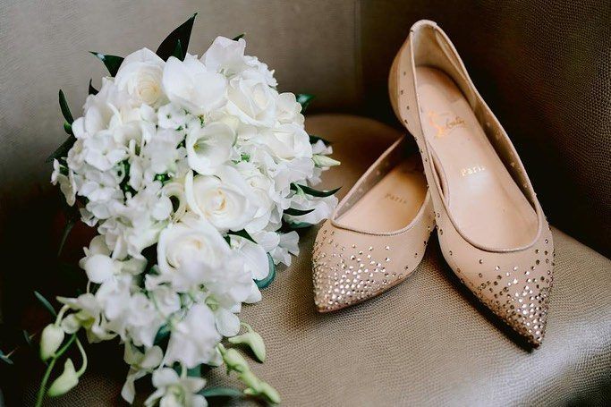 A bridal bouquet beside a pair of bridal shoes
