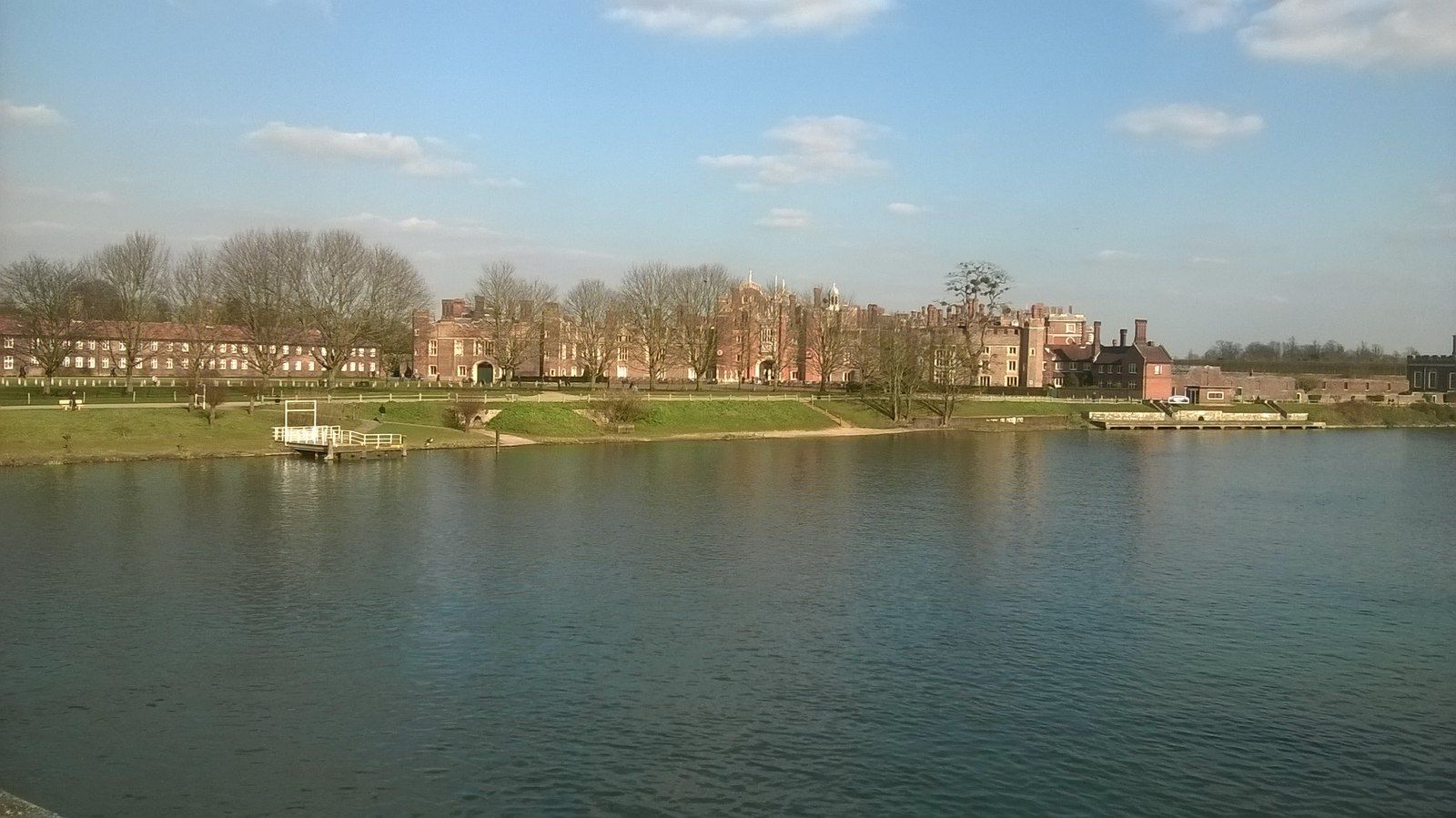 The palace low across the broad, calm waters of the Thames