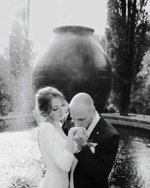 Beside the fountain, a kiss on the hand, in black and white, Ortica Wedding, Rome, Italy