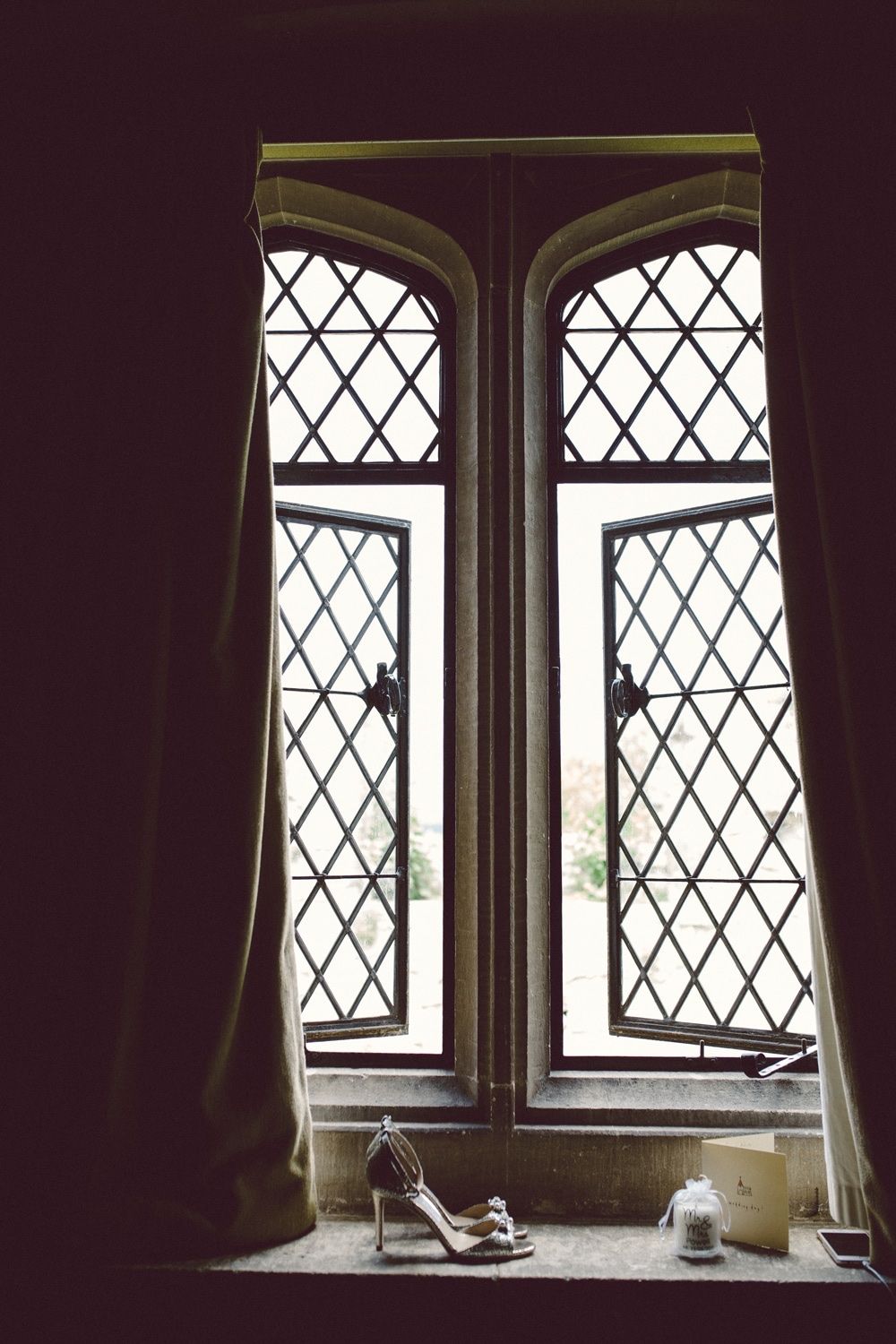 Bridal shoes on the sill of a gothic leaded window