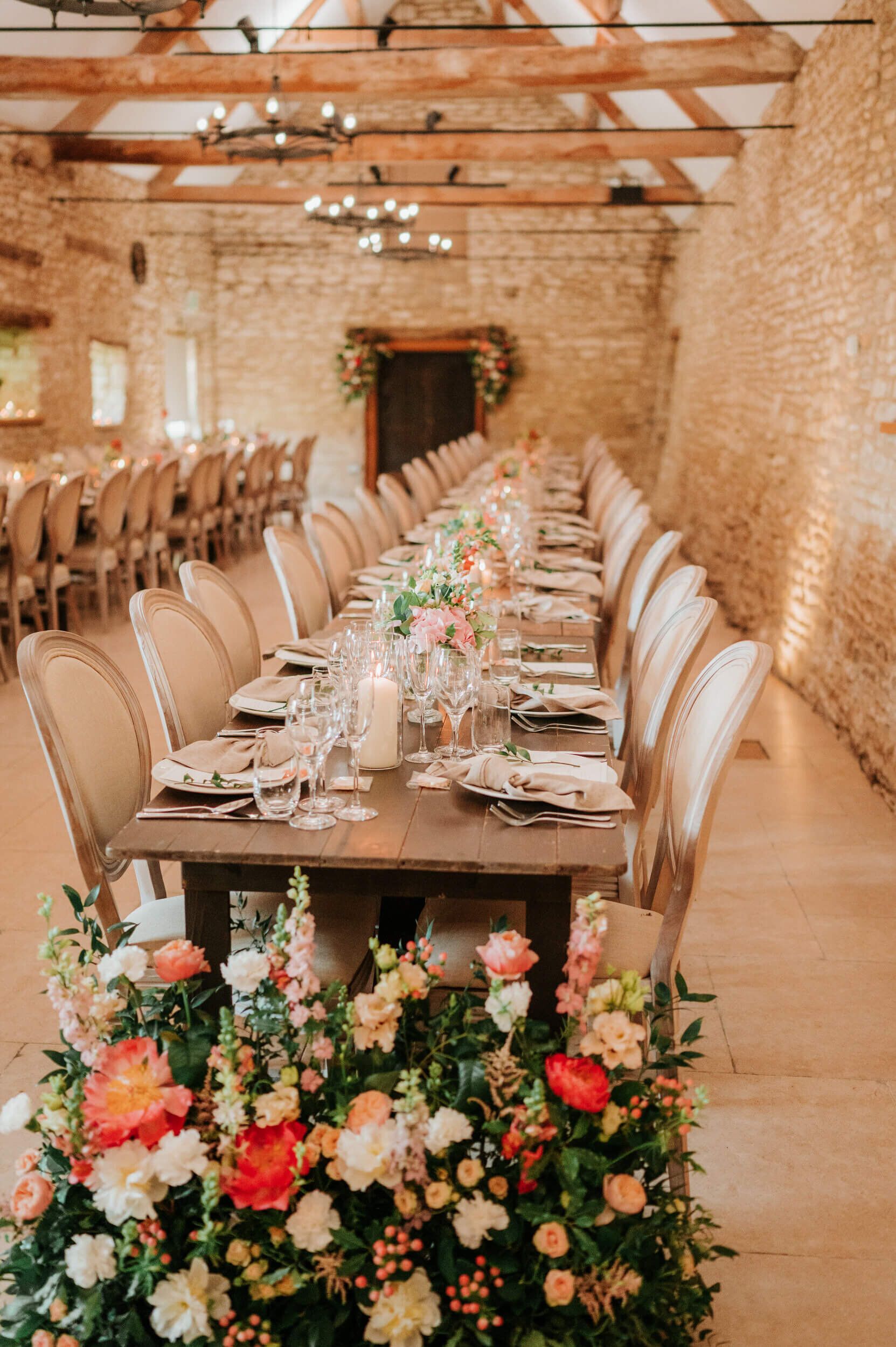 The wedding breakfast, set beneath the beams of one of the barns at Caswell House