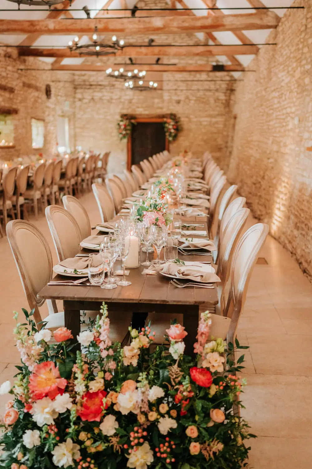 The wedding breakfast, set beneath the beams of one of the barns at Caswell House