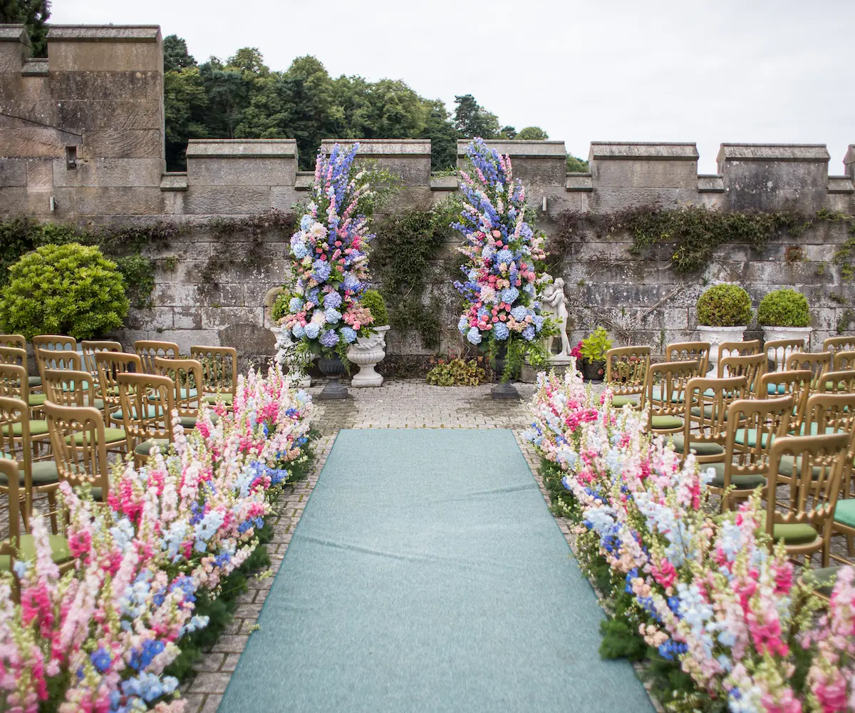 A bride down the courtyard aisle within the castle walls