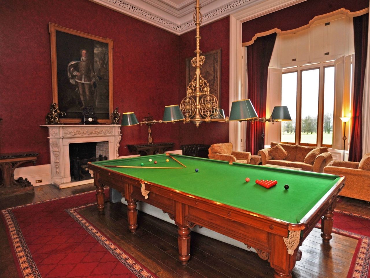 The Billiard Room, its snooker table beneath a chandelier and a portrait