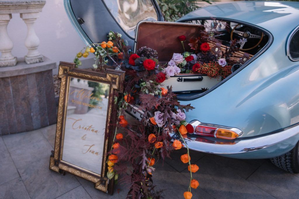 The boot of a vintage car, opened and filled with flowers