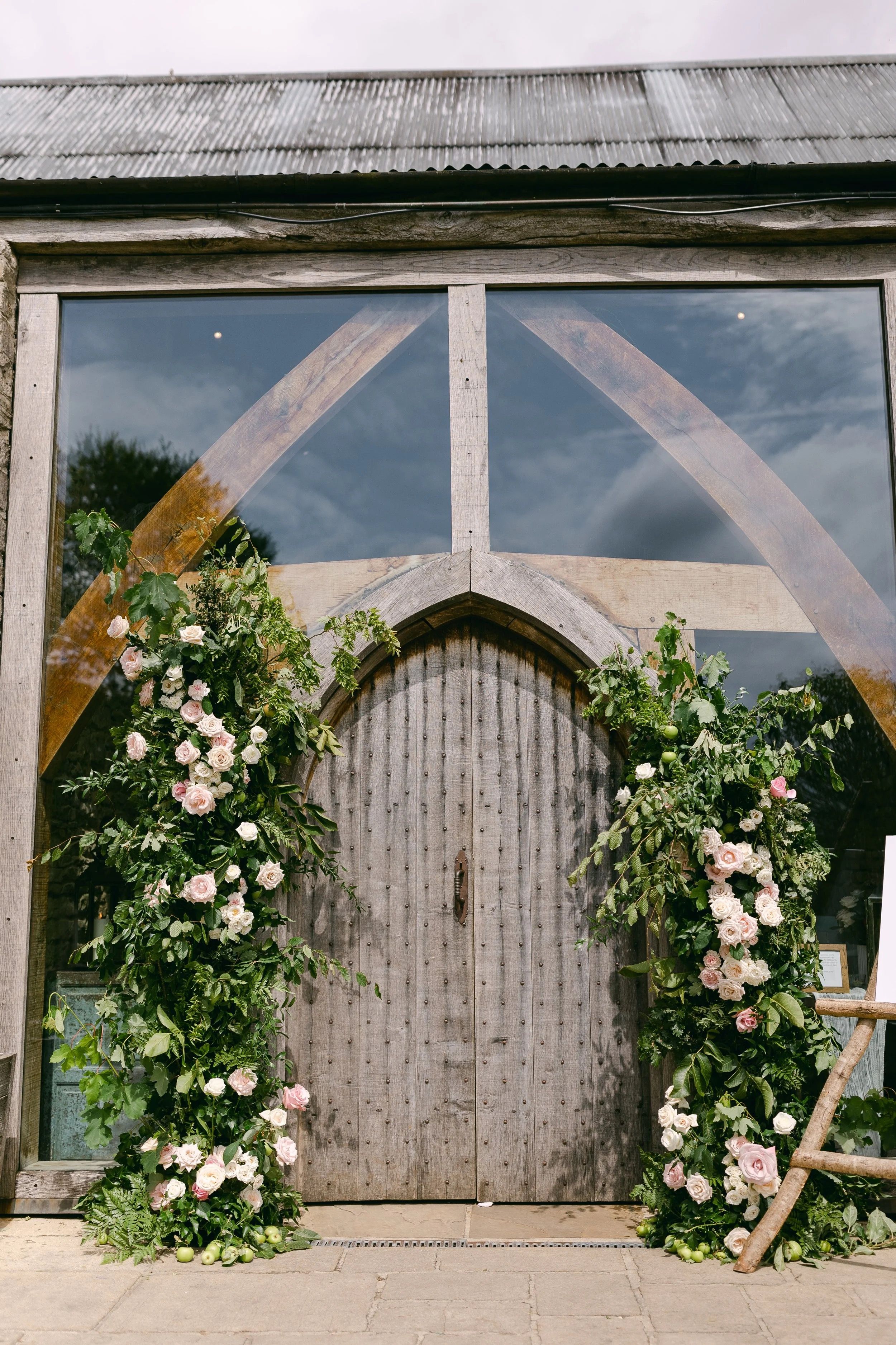 A rose and apple branch arch dresses the barn doors, Cripps Barn, Foxgloves and Roses, Wantage, England
