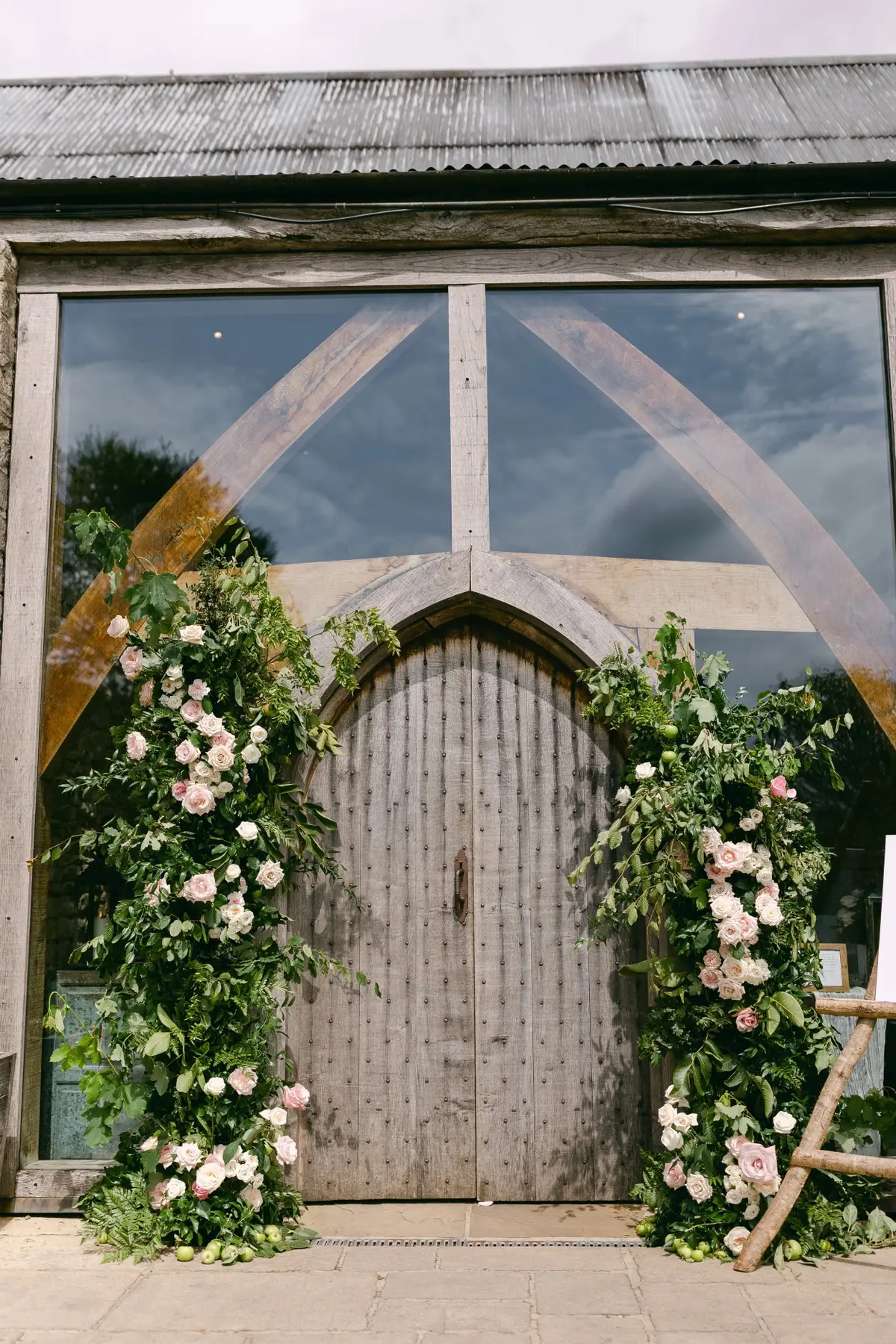 A rose and apple branch arch dresses the barn doors, Cripps Barn, Foxgloves and Roses, Wantage, England