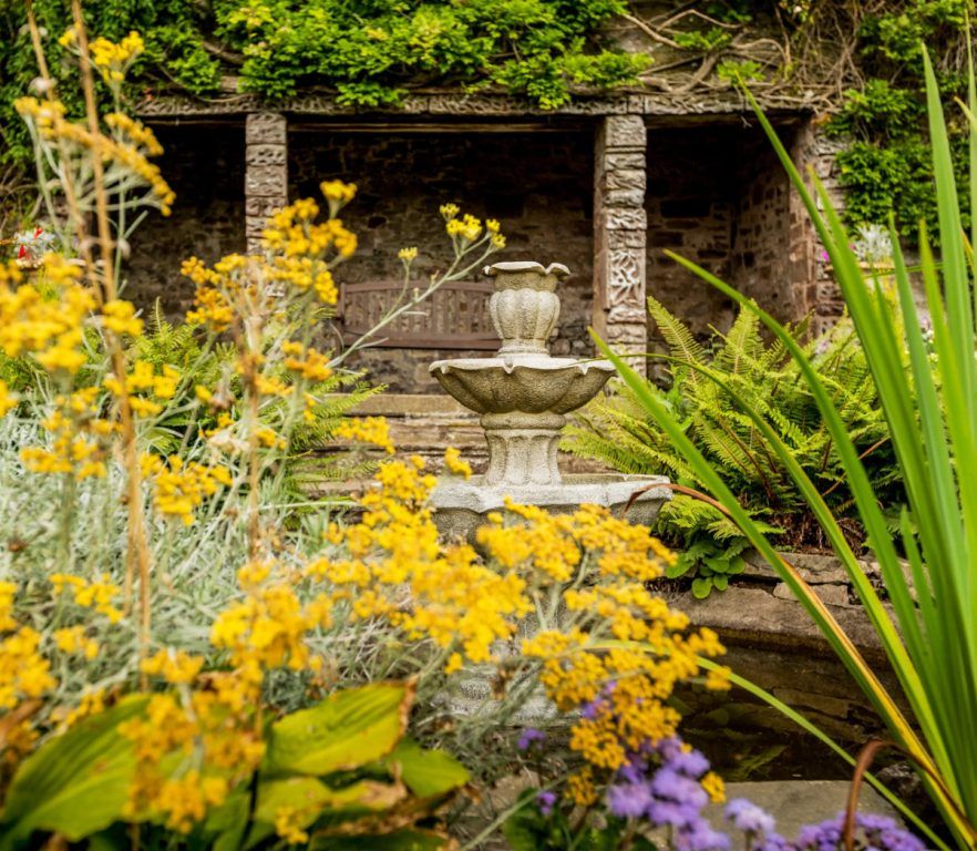 A stone fountain amid wildflowers in the award-winning walled garden