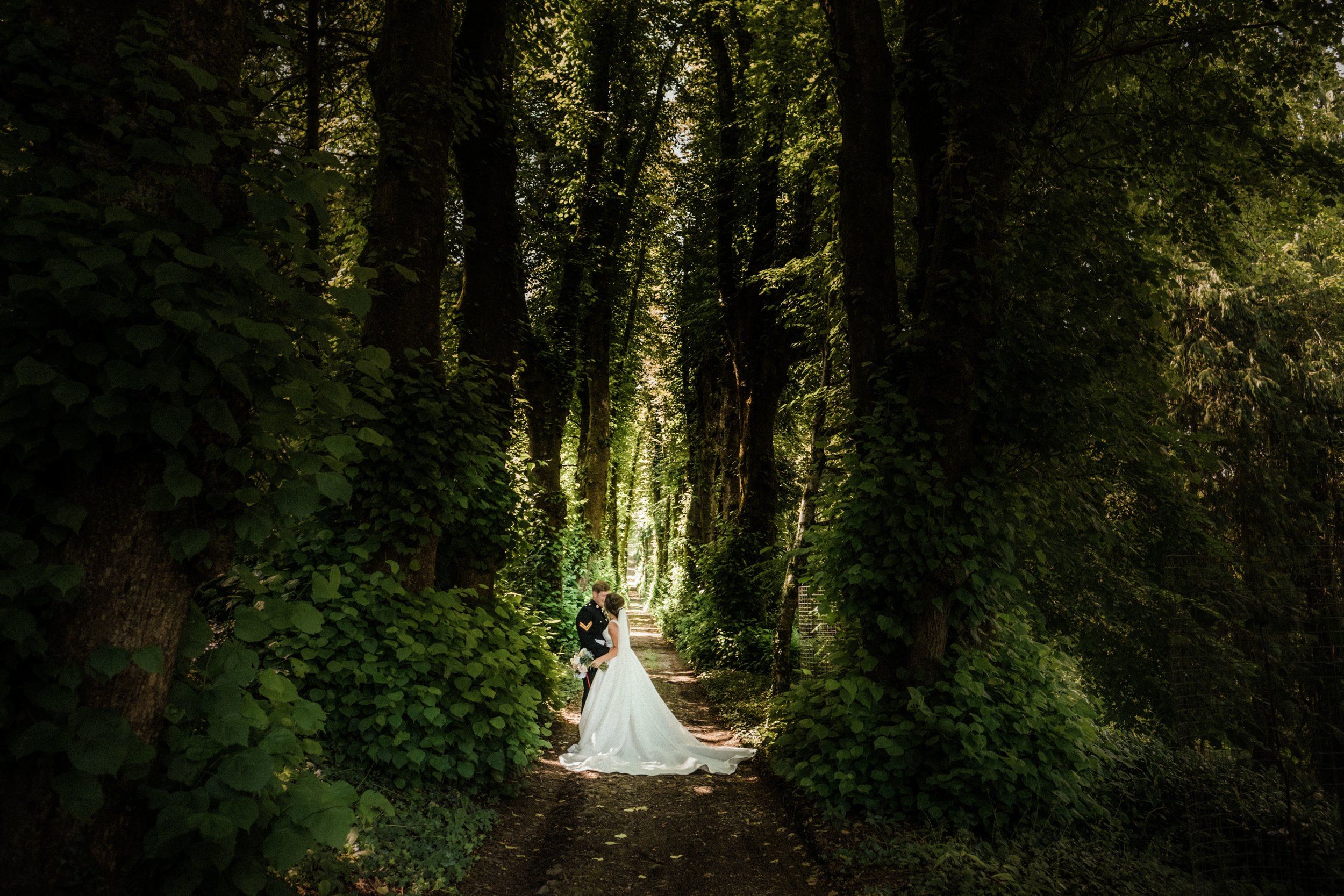 The bride on a green woodland path in the estate grounds, Pentillie Castle, Saltash, England