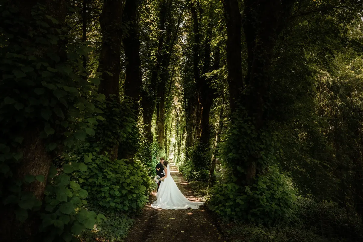 The bride on a green woodland path in the estate grounds, Pentillie Castle, Saltash, England