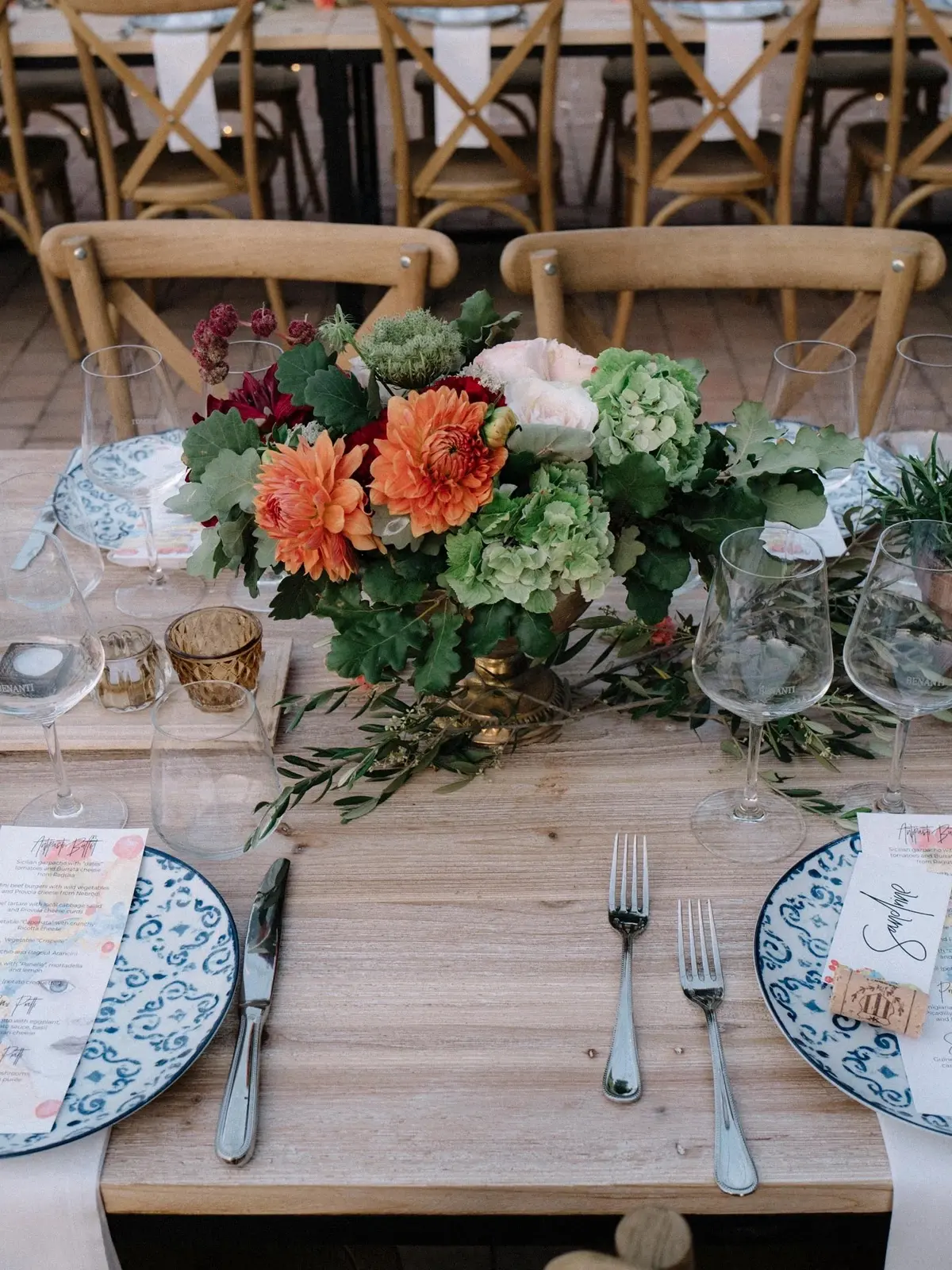 A reception table set with hand-painted Sicilian ceramics and orange dahlias