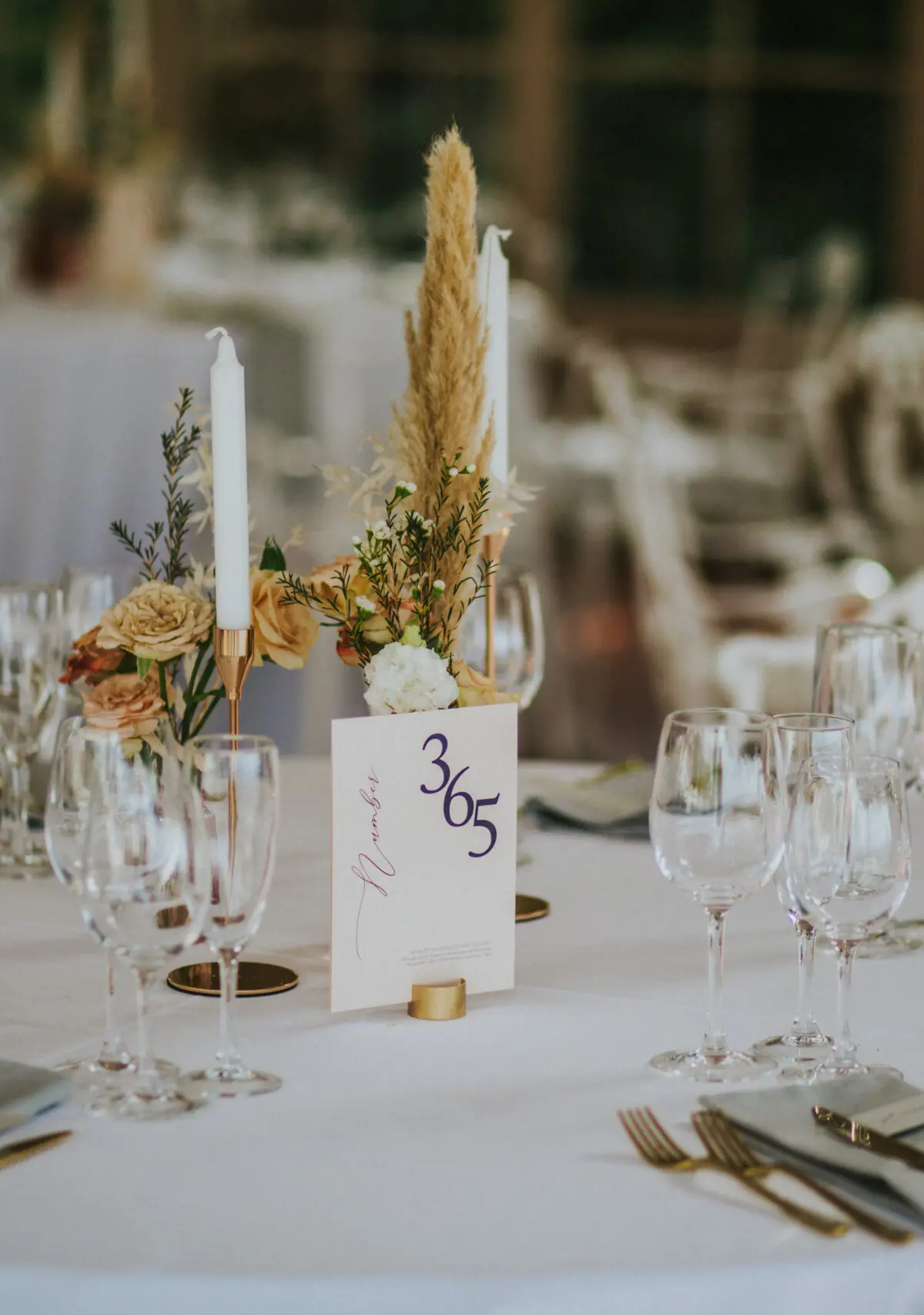 A reception table dressed with pampas grass and taper candles