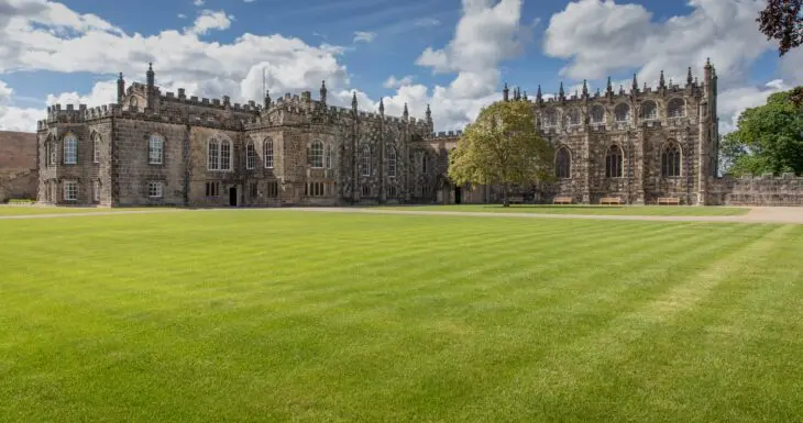 The castle's crenellated stone facade across the sweeping front lawn, Auckland Castle, Bishop Auckland, England