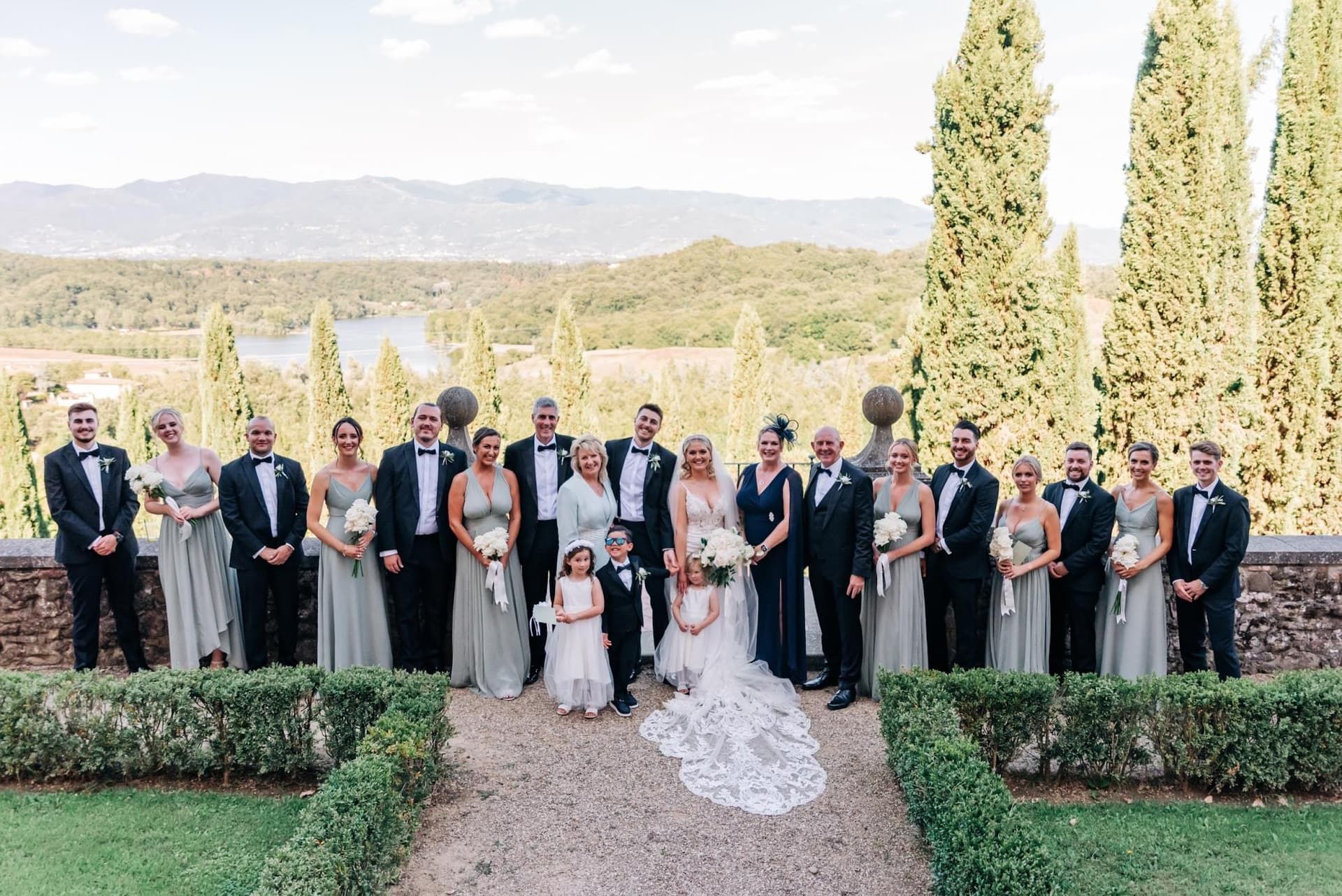 The whole party in the formal garden, cypresses behind