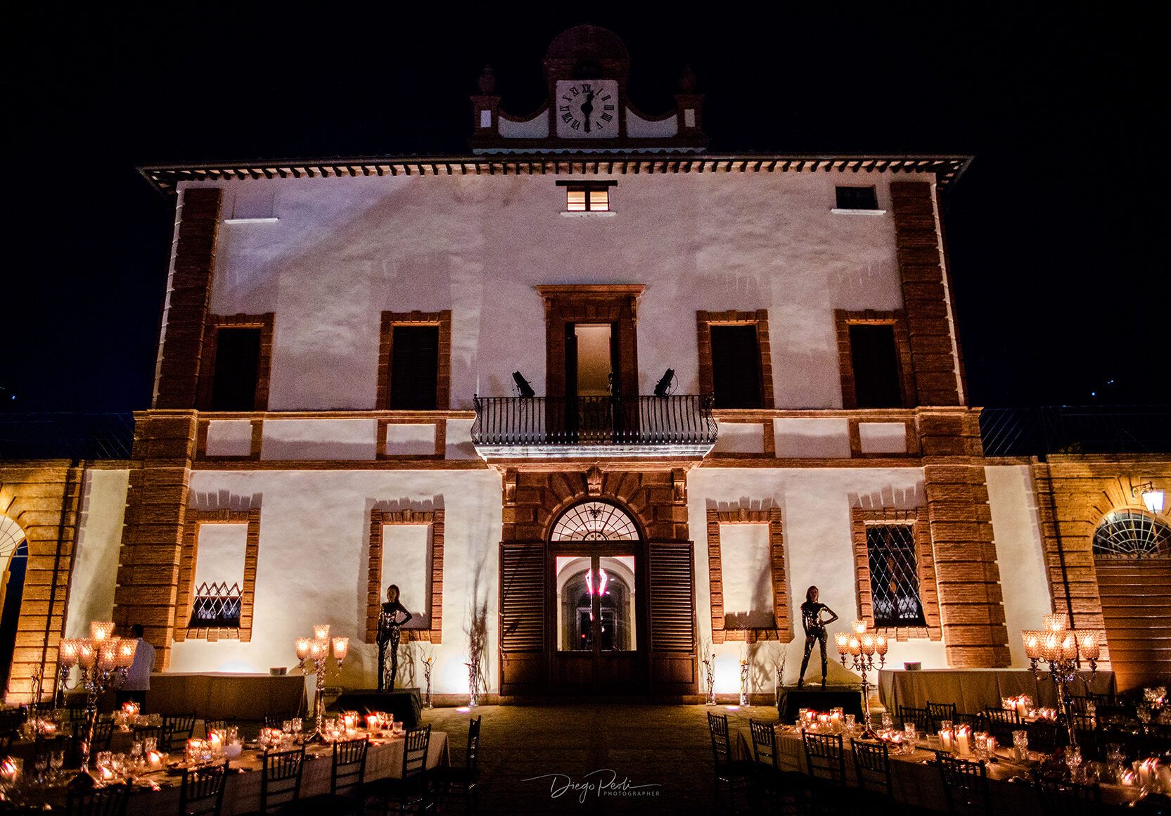 Castle facade lit at night, candlelit reception tables on the terrace