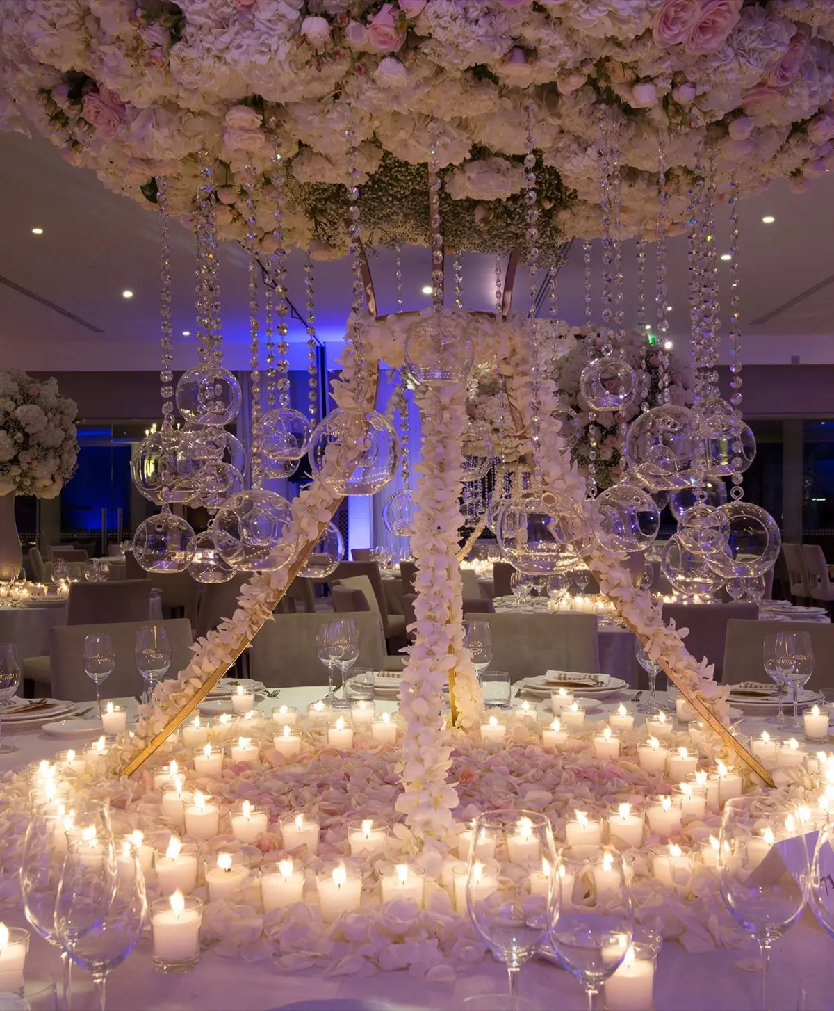 A floral chandelier over a candlelit reception