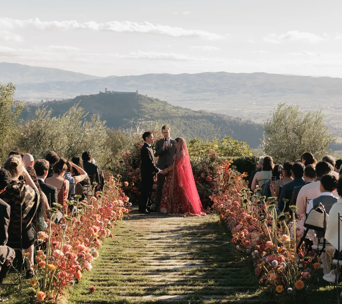 A ceremony aisle lined with autumn flowers above the Umbrian valley