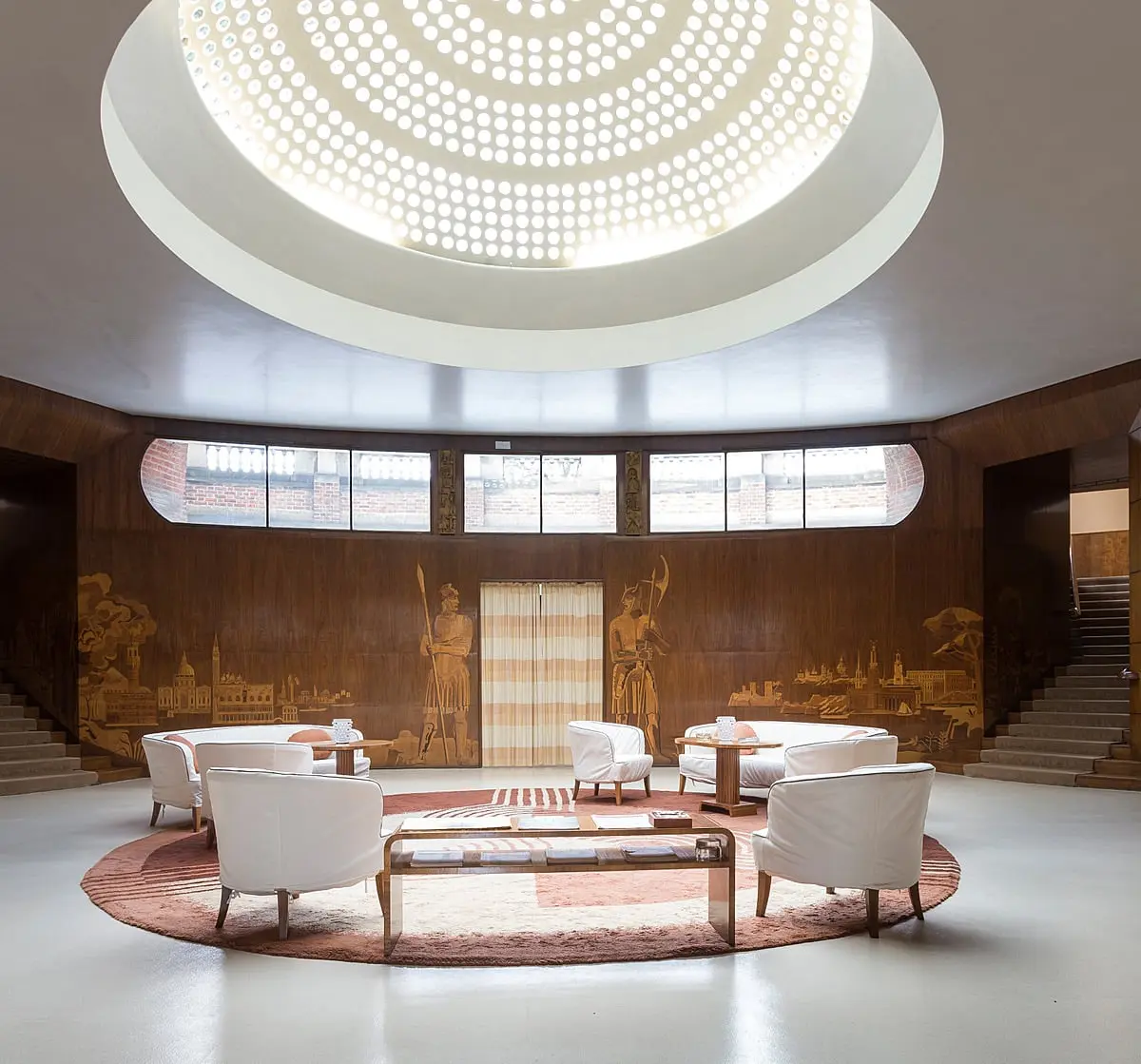 The Art Deco Entrance Hall, its glass dome, marquetry murals and twin staircases