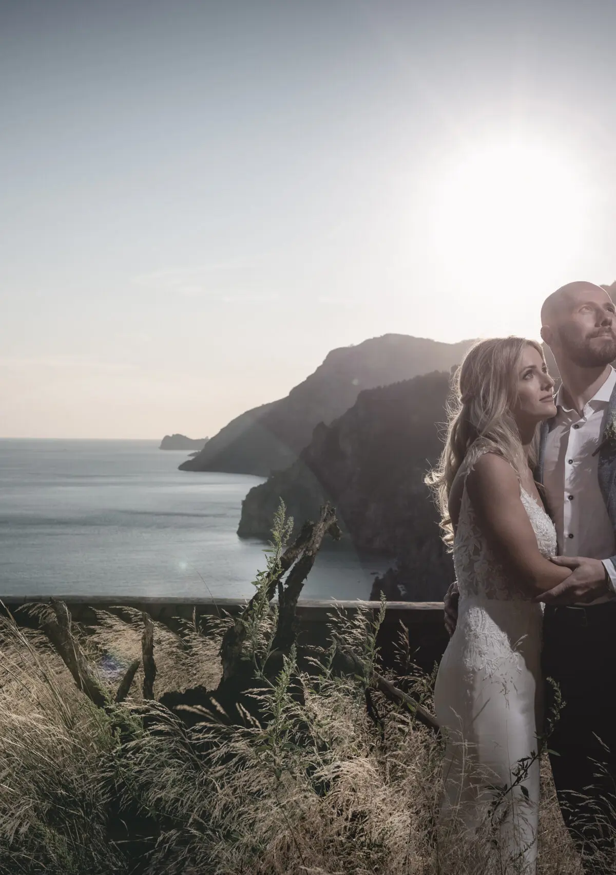A couple embracing on the cliffs above the Amalfi Coast at golden hour
