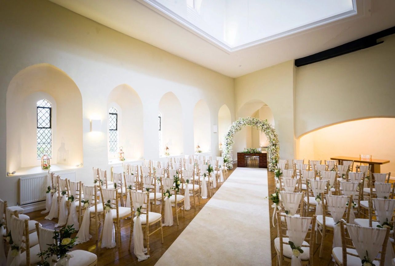 The Lantern Hall aisle, Chiavari chairs beneath its arches