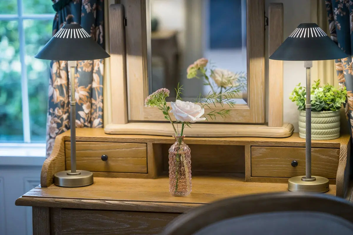 A dressing table with lamps and flowers in a guest room, Haselbury Mill, Crewkerne, England