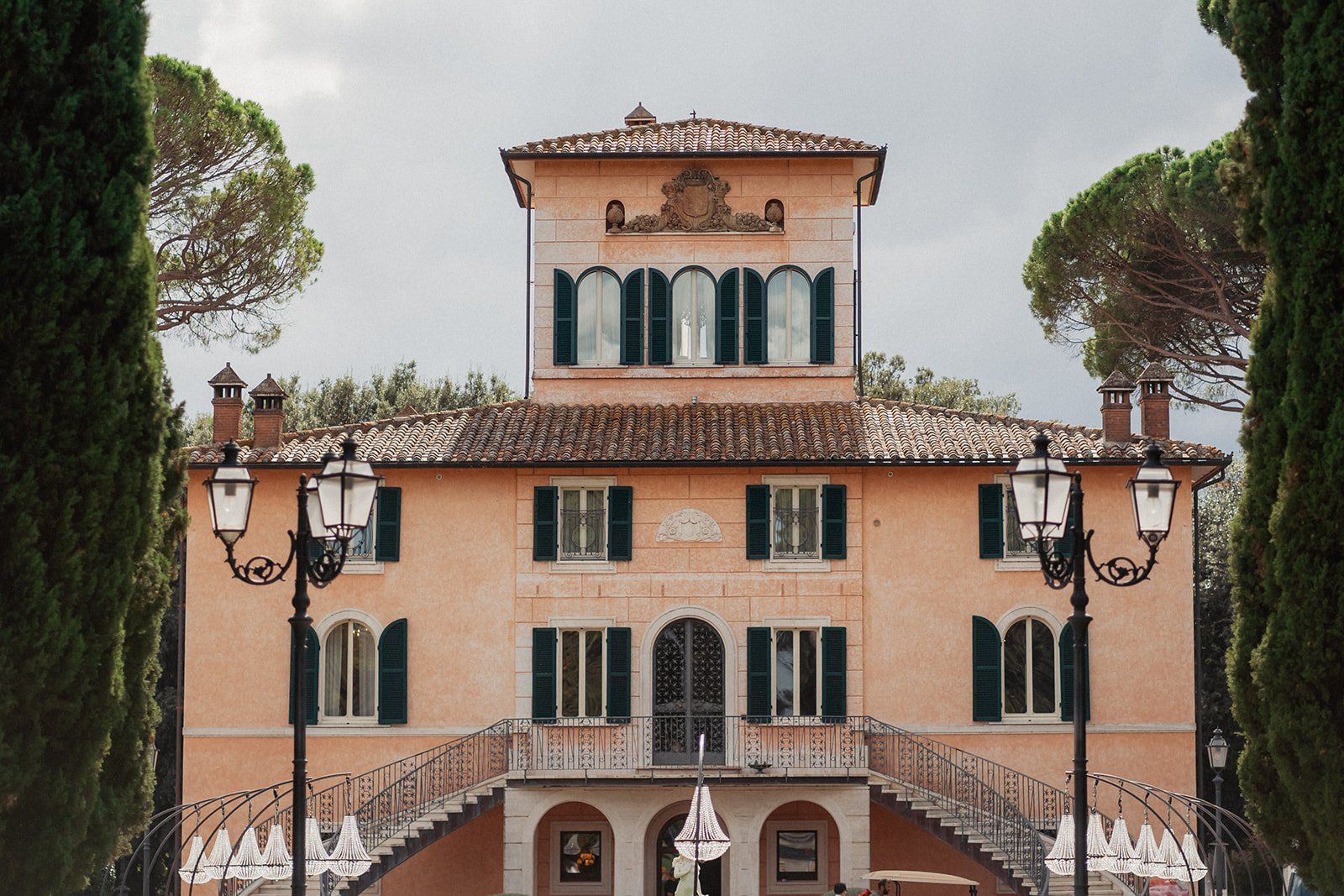 The pale terracotta facade of Villa Valentini Bonaparte, cypress-lined and shuttered, on the Tuscany/Umbria border
