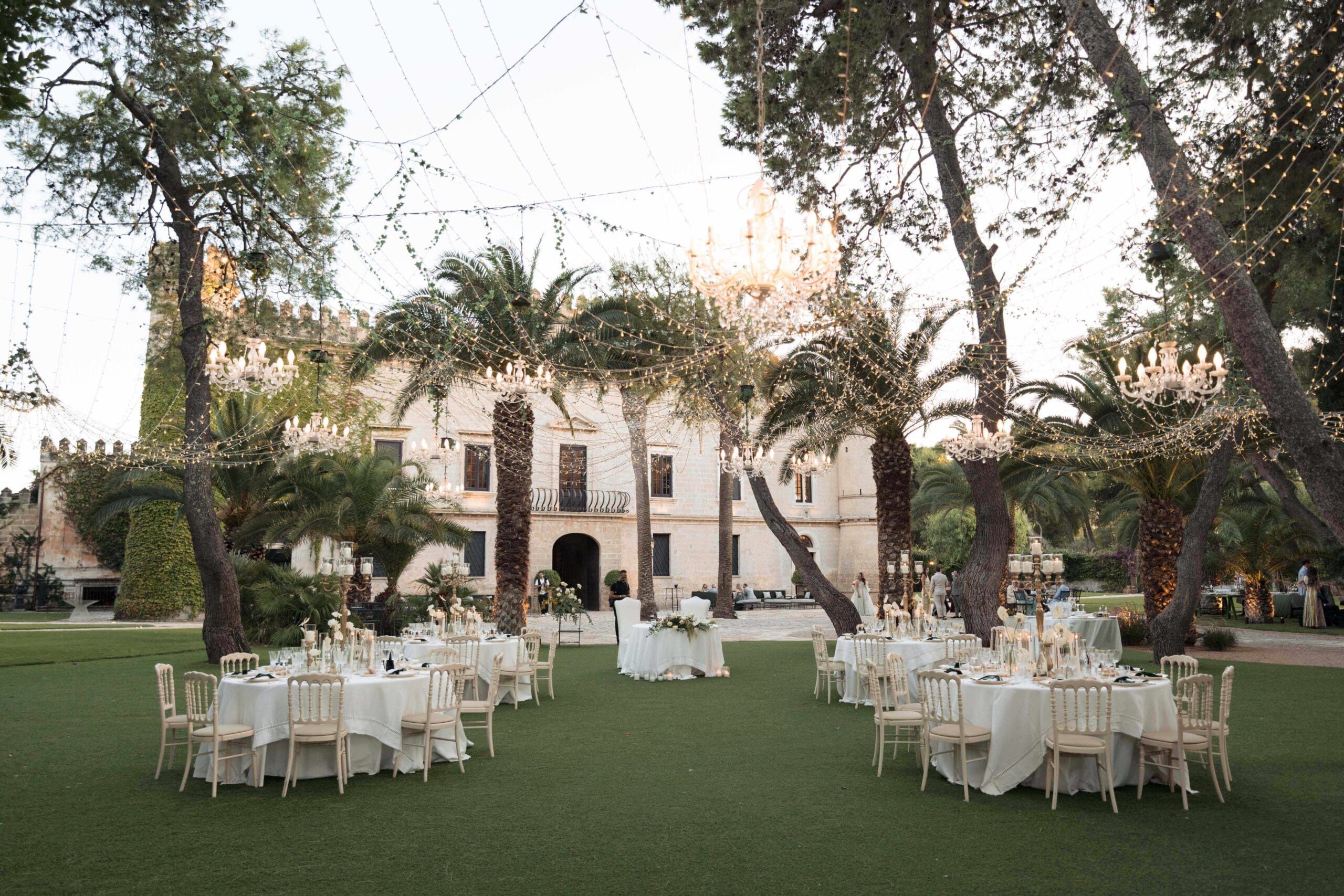 A castellated palazzo across its lawn, tables laid among the palms